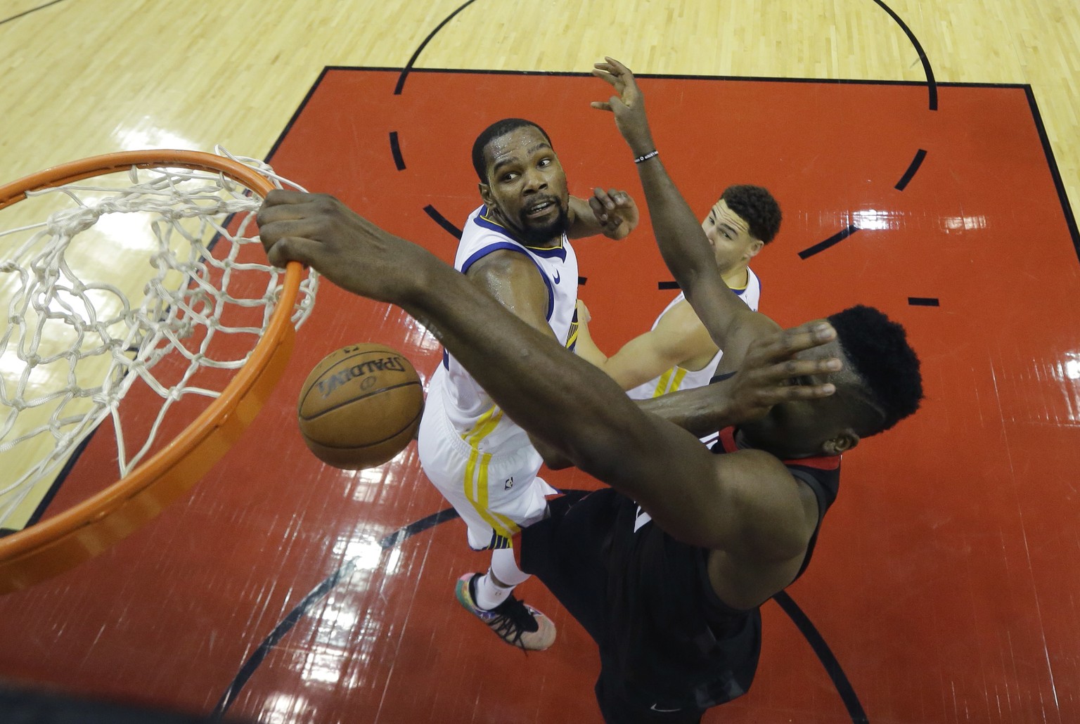Houston Rockets center Clint Capela, right, is hit in the face as he scores over Golden State Warriors forward Kevin Durant, left, in the first half during Game 7 of the NBA Western Conference Finals, ...