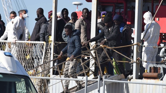epa10594052 A group of 250 migrants transferred from the hotspot on the island of Lampedusa disembark from the naval vessel Vega in the port of Catania, Italy, on April 27, 2023.  About 250 migrants are going…