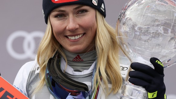 United States&#039; Mikaela Shiffrin celebrates on the podium with the trophy for the alpine ski women&#039;s overall World Cup title, in Meribel, France, Sunday, March 20, 2022. (AP Photo/Alessandro  ...