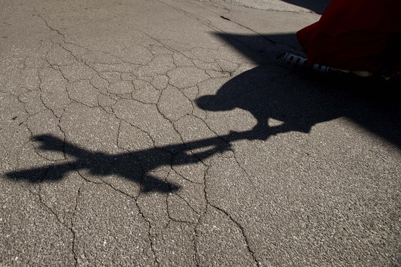 FILE - In this Friday, April 10, 2020. file photo, the shadow of a priest holding a crucifix is cast on the ground as he leads the Via Crucis, or Way of the Cross ceremony, at the Ospedale di Circolo  ...