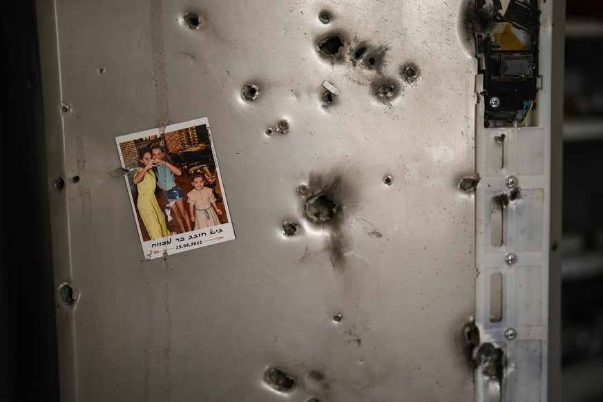 A photo hangs on a refrigerator full of bullet holes in a house in Kibbutz Kissufim in southern Israel, Saturday, October 8.  October 21, 2023. The kibbutz was overrun by Hamas militants from the nearby Gaza Strip...