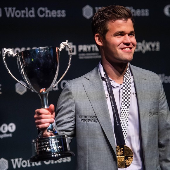 IMAGO / Bildbyran

181128 Magnus Carlsen of Norway celebrates with the trophy after the tie-break game of FIDE World Chess Championship 2018 between Magnus Carlsen and Fabiano Caruana on November 28,  ...
