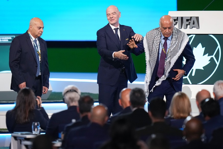 Palestinian Football Association President Jibril Rajoub, right, walks away from FIFA President Gianni Infantino, center, after refusing to stand together with Israel Football Association Vice-Preside ...