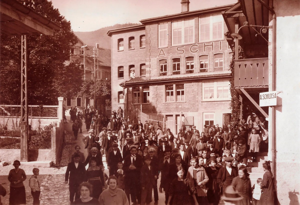 Uhrenarbeiterinnen und Uhrenarbeiter der A. Schild SA (Assa) verlassen nach Feierabend die Fabrik. Foto aus dem Jahr 1924.