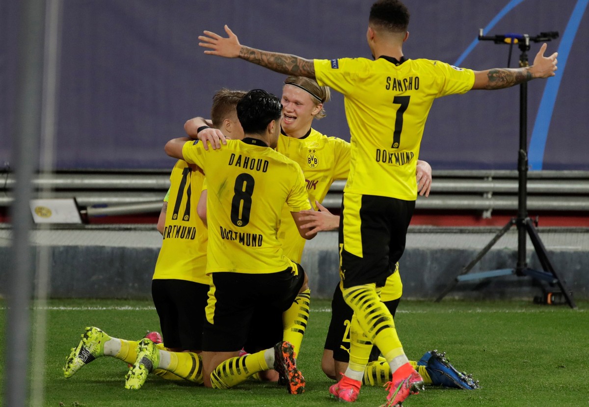epa09019769 Borussia Dortmund's striker Erling Haaland (C) celebrates with teammates after scoring the 1-3 lead during the first leg of the UEFA Champions League round of 16 soccer match between  ...