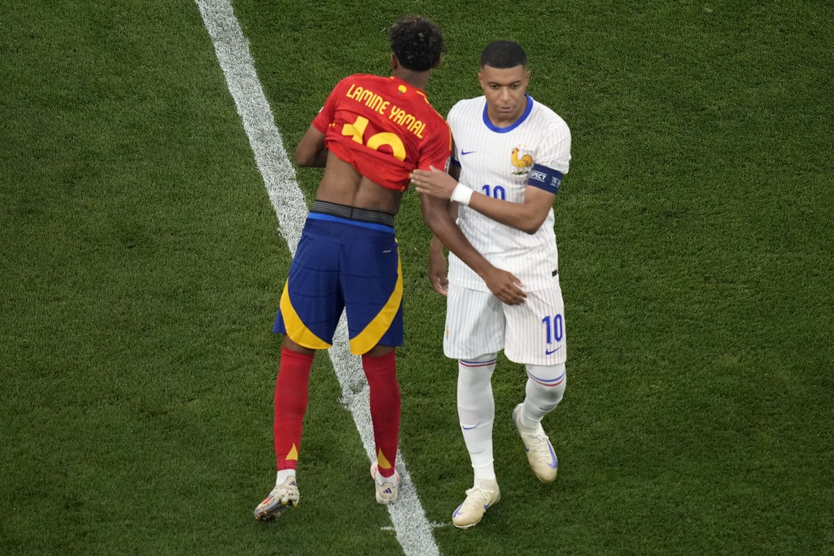 Spain's Lamine Yamal embraces Kylian Mbappe of France ahead of a semifinal match between Spain and France at the Euro 2024 soccer tournament in Munich, Germany, Tuesday, July 9, 2024. (AP Photo/A ...