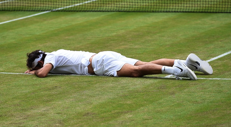 epa05415473 Roger Federer of Switzerland takes a fall as he plays Milos Raonic of Canada in their semi final match during the Wimbledon Championships at the All England Lawn Tennis Club, in London, Br ...