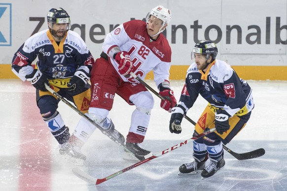 Harri Pesonen, mitte, von Lausanne im Spiel gegen Josh Holden, links, und Lino Martschini, rechts, von Zug beim Eishockey Meisterschaftsspiel in der Qualifikation der National League zwischen dem EV Z ...