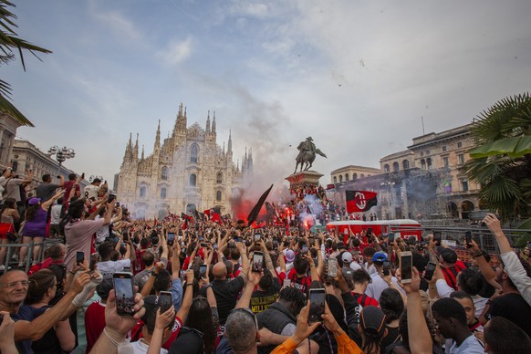 AC Milan fans celebrate in Piazza Duomo square after a Serie A soccer match between Sassuolo and AC Milan, being played in Reggio Emilia, in Milan, Italy, Sunday, May 22, 2022. AC Milan secured its fi ...