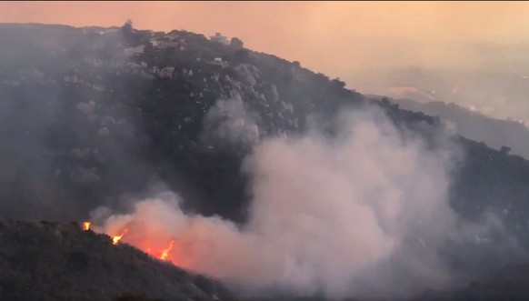 In this image taken from video provided by the Santa Barbara County Fire Department, a wind driven spot fire burns on the west side below Gibraltar Road as smoke from a wildfire fills the air in Santa ...