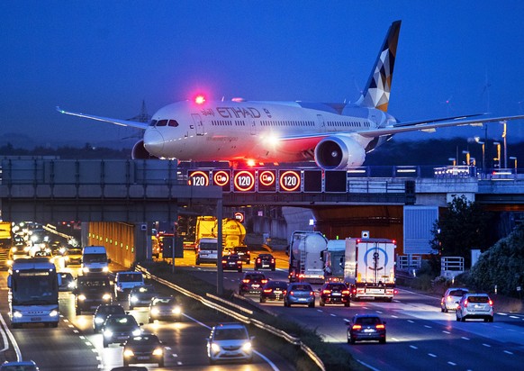 FILE - In this Friday, Sept. 20, 2019 file photo an aircraft crosses a bridge over a highway the airport in Frankfurt, Germany.(AP Photo/Michael Probst, File)