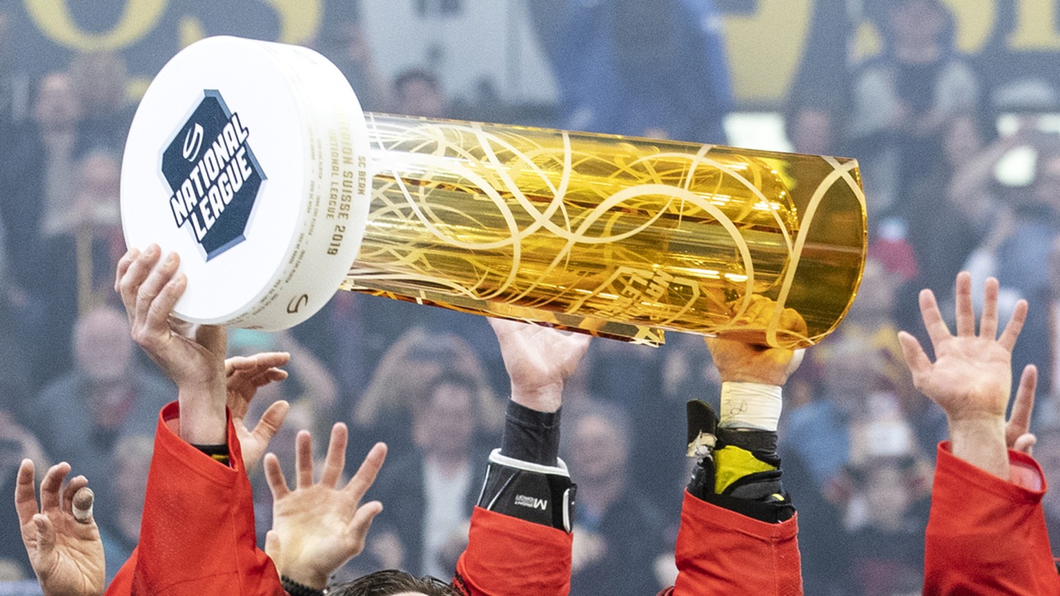 ARCHIV - ZUM JAHRESRUECKBLICK 2019 - SPORT STELLEN WIR IHNEN FOLGENDES BILDMATERIAL ZUR VERFUEGUNG - Simon Moser und die Spieler des SC Bern feiern mit dem Pokal den Schweizermeistertitel nach dem Sie ...