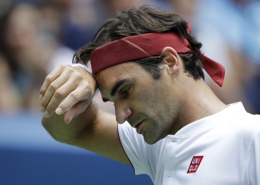 Roger Federer, of Switzerland, wipes his face against Benoit Paire, of France, during the second round of the U.S. Open tennis tournament, Thursday, Aug. 30, 2018, in New York. (AP Photo/Kevin Hagen)