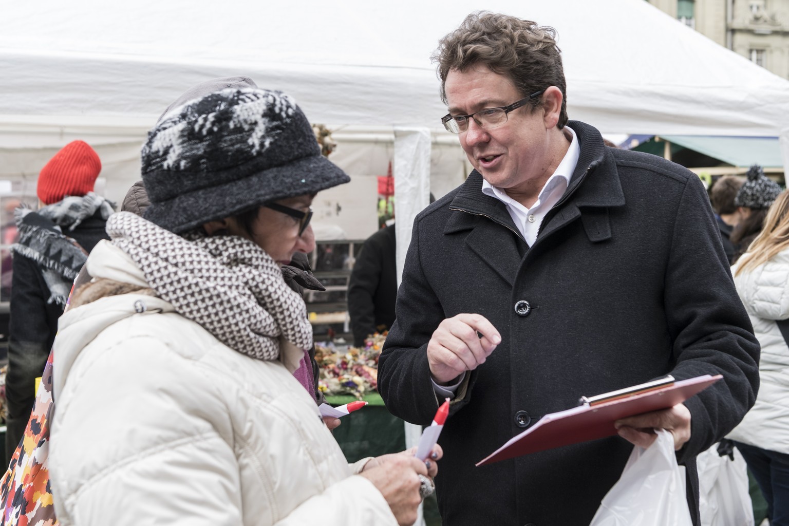 SVP-Praesident Albert Roesti, SVP-BE, rechts, im Gespraech mit einer Passantin, eroeffnet die Unterschriftensammlung fuer ein Referendum gegen die Energiestrategie 2050, welche vom Parlament verabschi ...