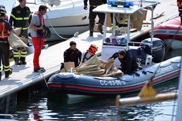 epa10662226 Carabinieri and fire brigade officers take part in the search and rescue operation in Lake Maggiore after a tourist boat capsized near Lisanza (Varese), northern Italy, 29 May 2023. At lea ...