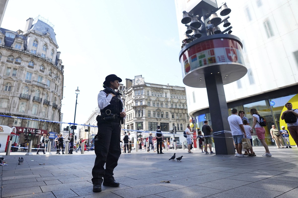 A Police officer stands at the scene in Leicester Square, as a man was arrested with the accusation of stabbing an 11-year-old girl and 34-year-old woman, in London, Monday Aug. 12, 2024. (James Manni ...
