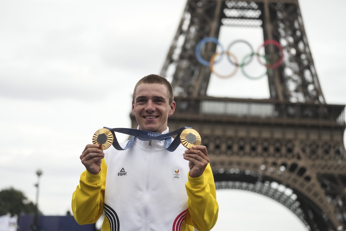 Remco Evenepoel, of Belgium, shows his gold medals of the men's time trial and road cycling events, at the 2024 Summer Olympics, Saturday, Aug. 3, 2024, in Paris, France. (AP Photo/Thibault Camus ...