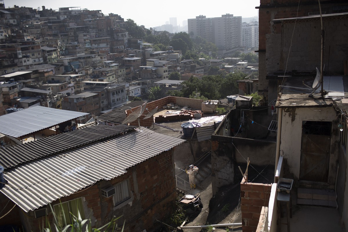 A water utility worker from CEDAE disinfects the Turano favela in an effort to curb the spread of the new coronavirus in Rio de Janeiro, Tuesday, June 9, 2020. (AP Photo/Silvia Izquierdo)