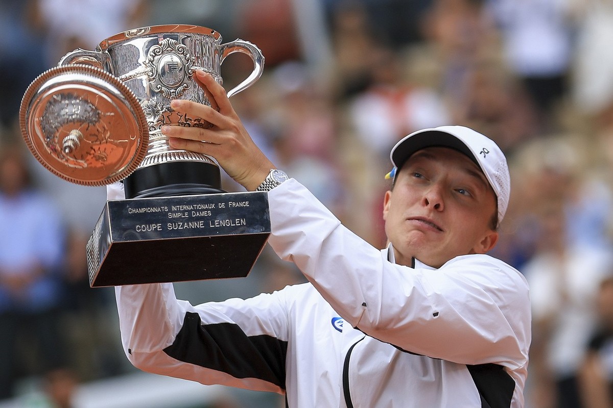 The lid flies off the trophy as Poland's Iga Swiatek celebrates winning the women's final match of the French Open tennis tournament against Karolina Muchova of the Czech Republic in three s ...