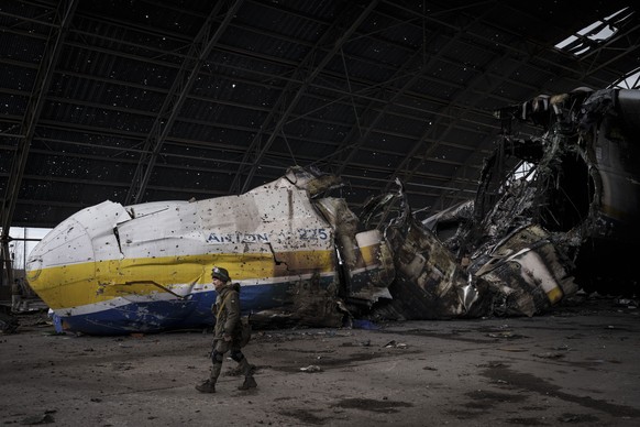A Ukrainian serviceman walks past the Antonov An-225 aircraft destroyed during fighting between Russian and Ukrainian forces, at the Antonov airport in Hostomel, outskirts of Kyiv, Ukraine, Monday, Ap ...