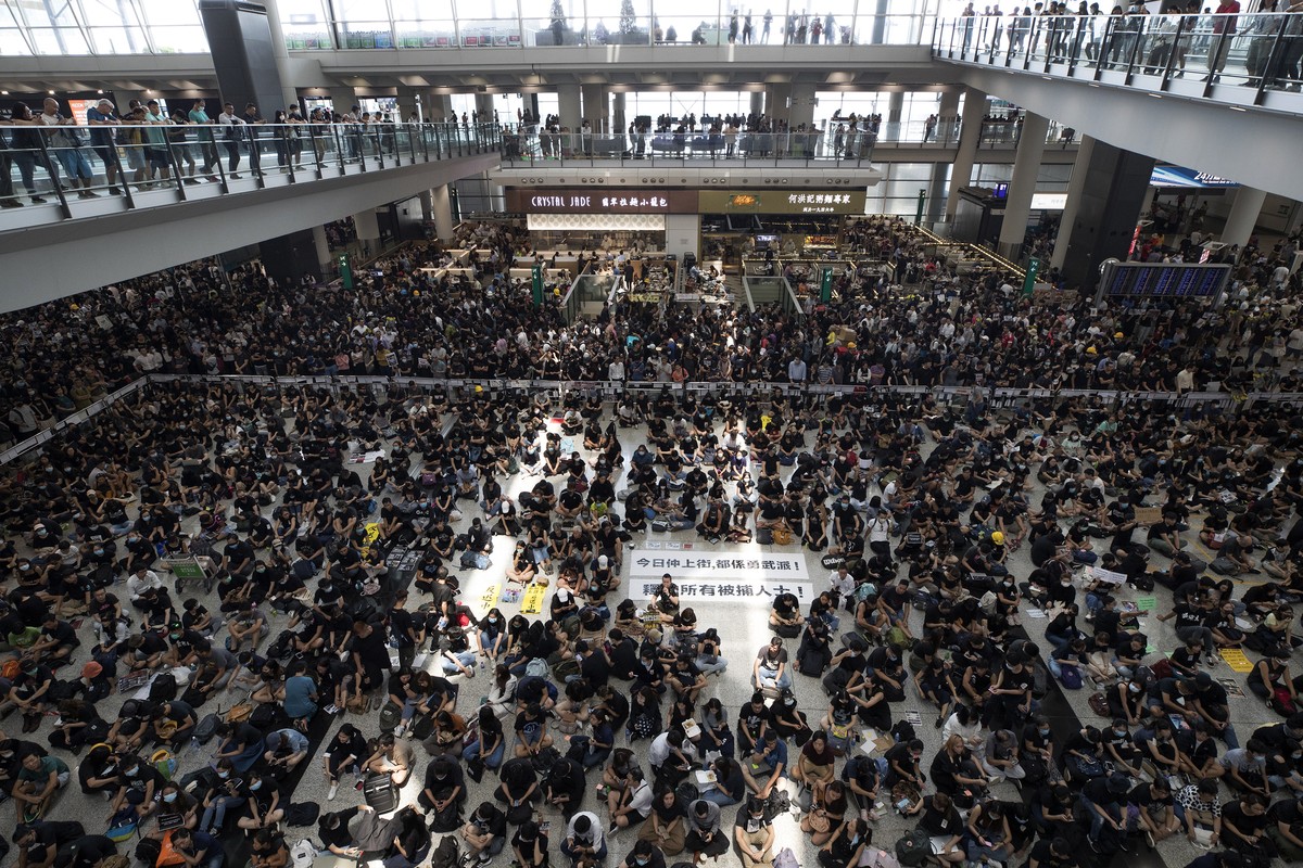 THIS ADDS TO CLARIFY THE TRANSLATION - Protesters surround banners that read: "Those on the street today are all warriors!" center top, and "Release all the detainees!" during a si ...