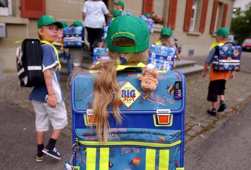 Erstklaessler auf dem Weg zum Schulhaus, am Montag, 9.August 2004 in Schwarzenburg. Die Kinder erhalten im Gebiet des Polizeikonkordats Nordwestschweiz farbige Basketballmuetzen, welche einen Beitrag  ...