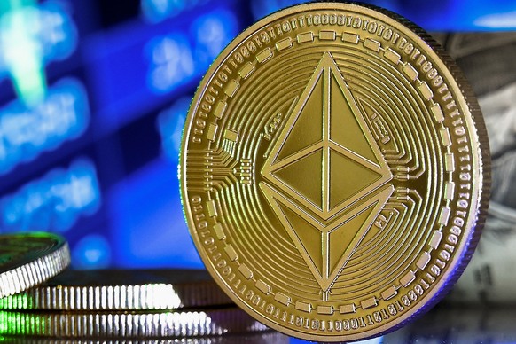 epa08951383 An Ethereum coin in front of a monitor showing a stock barometer in Duesseldorf, Germany, 20 January 2021. Cryptocurrency Bitcoin has experienced drastic ups and downs in recent weeks and  ...