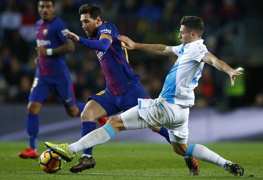 FC Barcelona&#039;s Lionel Messi, left, duels for the ball against Deportivo Coruna&#039;s Fabian Schar during the Spanish La Liga soccer match between FC Barcelona and Deportivo Coruna at the Camp No ...