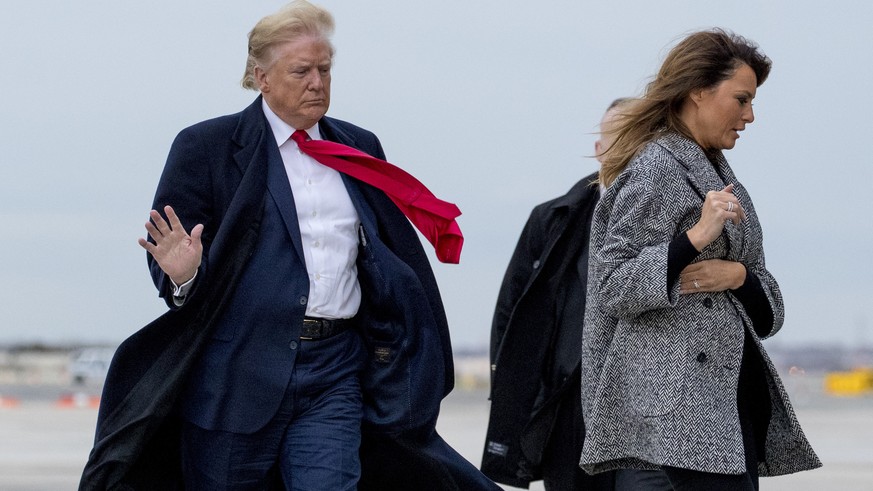 President Donald Trump and first lady Melania Trump walk to board Air Force One on a cold and windy afternoon at John F. Kennedy International Airport in New York, Tuesday, Nov. 12, 2019, to travel to ...
