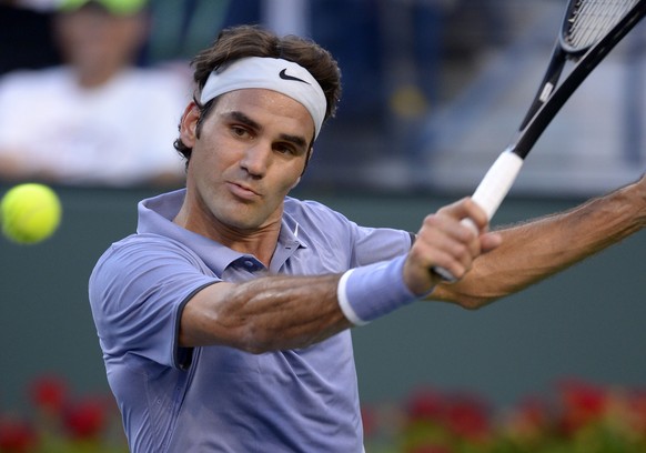 epa04122541 Roger Federer of Switzerland returns a shot to Tommy Haas of Germany during their match at the BNP Paribas Open in Indian Wells, California USA, 12 March 2014. Federer won the match.  EPA/PAUL BUCK