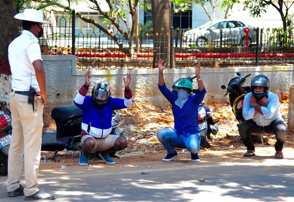 epaselect epa08330002 Indian traffic policeman stops bike riders and imposes punishment on them after they broke the lockdown on the fifth day of nation-wide lockdown as a precaution against the sprea ...