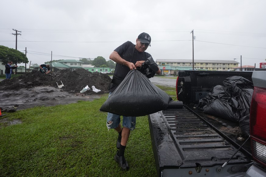 Darren Montalvo loads into the bed of his truck sand bags he will use to help keep water out of his restaurant as Hurricane Nolo approaches in Hilo, Hawaii, Friday, Sept. 25, 2026. (AP Photo/Gregory B ...