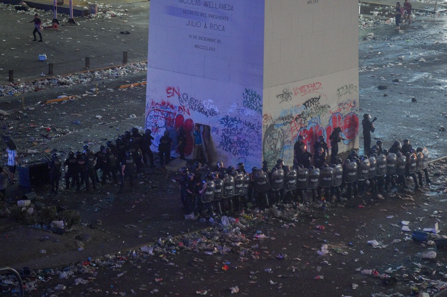 Police clear remaining soccer fans who waited for hours for a homecoming parade for the players who won the World Cup at the Obelisk in Buenos Aires, Argentina, Tuesday, Dec. 20, 2022. A parade to cel ...