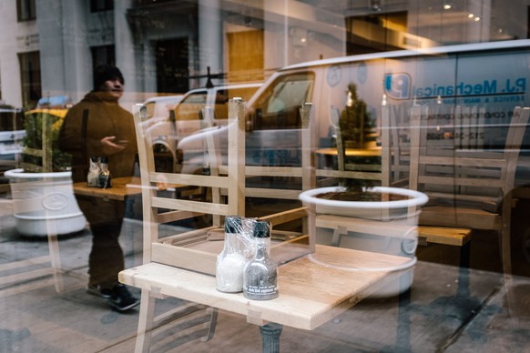 epa08302281 A man walks by a closed restaurant in New York, New York, USA, 17 March 2020. New York, as with most cities around the United States and the world, are trying to mitigate the spread of the ...