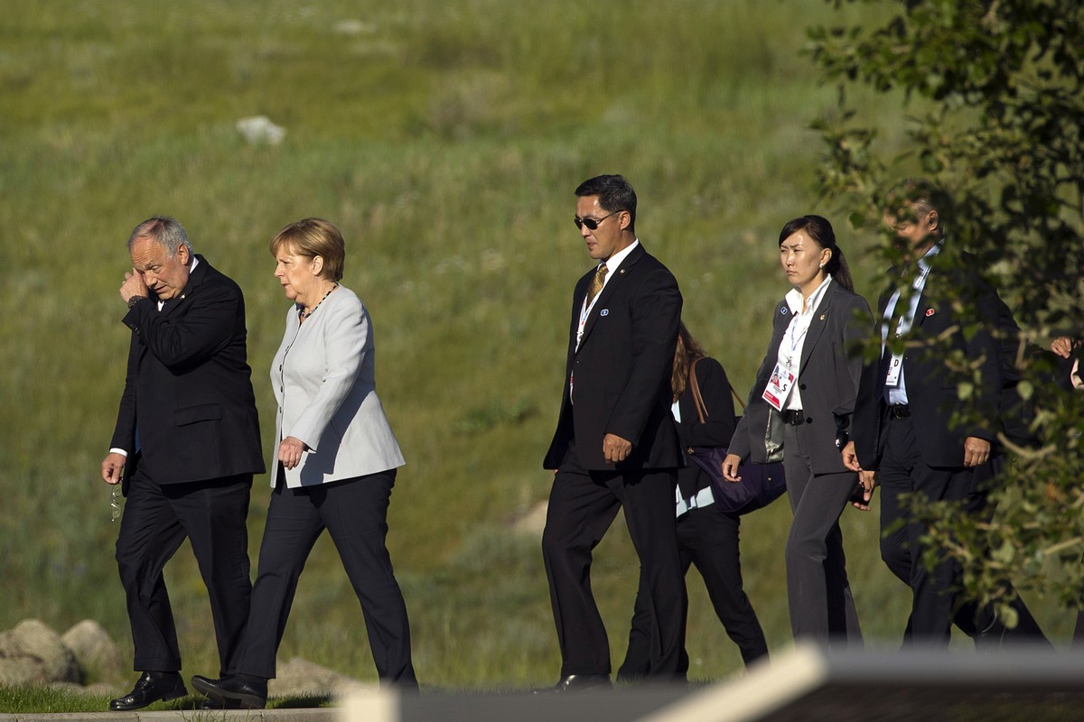 German Chancellor Angela Merkel, second from left, walks with Switzerland's President Johann Schneider-Ammann, left, as they arrive for a group photo of leaders at the 11th Asia-Europe Meeting (A ...