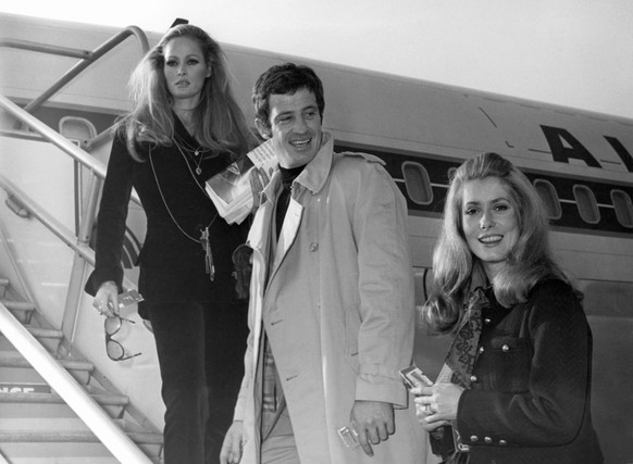 FILE - In this Nov. 29, 1968 file photo, actress Ursula Andress, left, joins Jean-Paul Belmondo, center, and Catherine Deneuve, right, on the gangway of the plane in Orly airport, France. French New W ...
