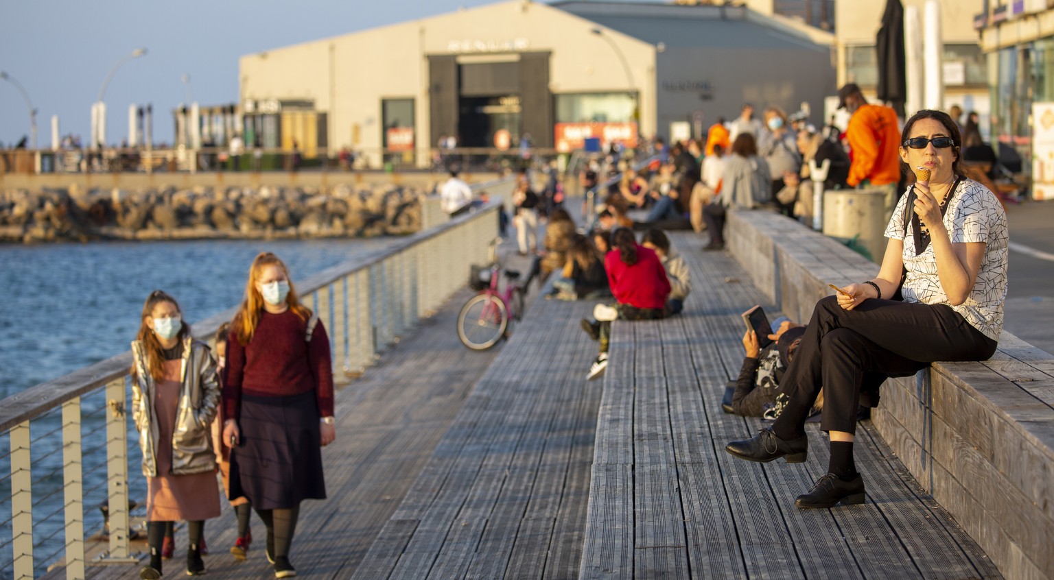 People enjoy the promenade on the Mediterranean sea in Tel Aviv, Israel, Sunday, Feb. 7, 2021. Israel has started to ease restrictions nearly six weeks after entering its third nationwide lockdown to  ...