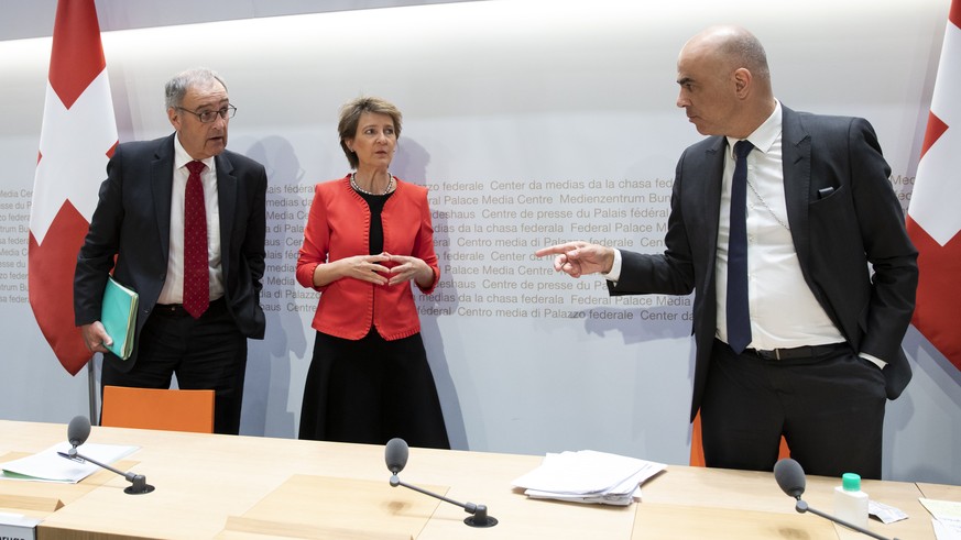 Bundesrat Alain Berset diskutiert mit Bundespraesidentin Simonetta Sommaruga und Bundesrat Guy Parmelin, am Ende einer Medienkonferenz des Bundesrates ueber die Situation des Coronavirus, am Donnersta ...