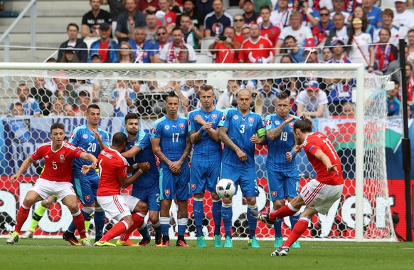 Wales&#039;s Gareth Bale, right, shoots a free kick to score the opening goal during the Euro 2016 Group B soccer match between Wales and Slovakia, at the Nouveau stadium in Bordeaux, France, Saturday ...