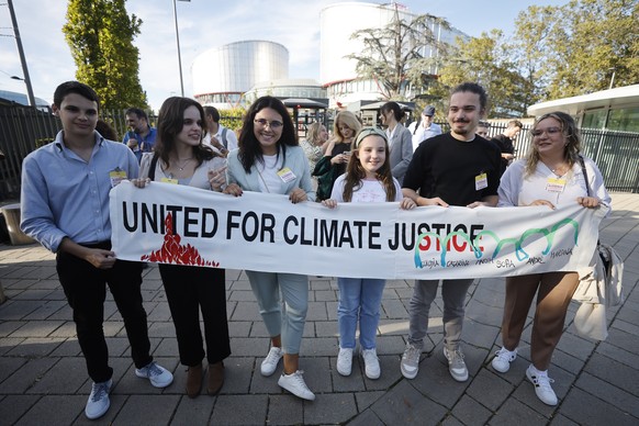 FILE - Mariana, center right, Claudia Agostinho, right, Martim Agostinho, second right, Sofia Oliveira, second left, her brother Andre, left, with Catarine Mota, pose with a banner outside the Europea ...