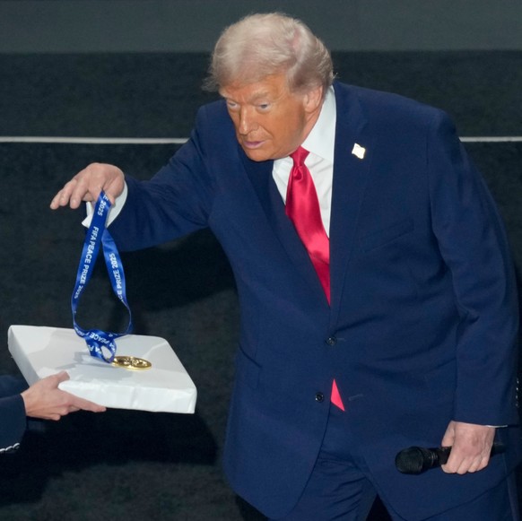 FIFA President Gianni Infantino, right, awards President Donald Trump with the FIFA Peace Prize during the draw for the 2026 soccer World Cup at the Kennedy Center in Washington, Friday, Dec. 5, 2025. ...