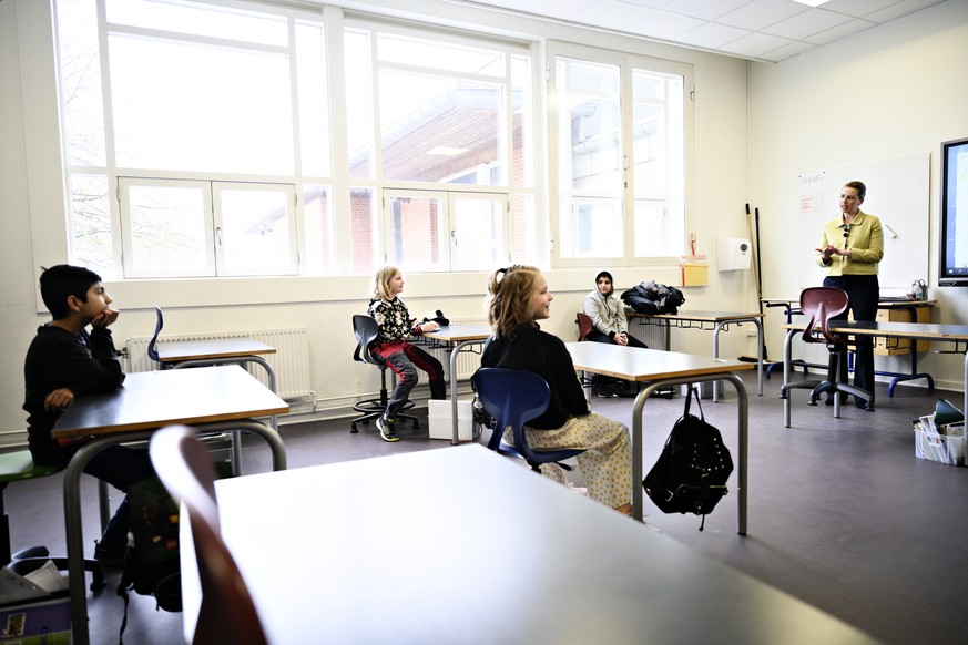 epa08363577 Danish Prime Minister, Mette Frederiksen (R), speaking with the pupils when she participates in the reopening of Lykkebo School in Valby in Copenhagen, Denmark, 15 April 2020. Starting 15  ...