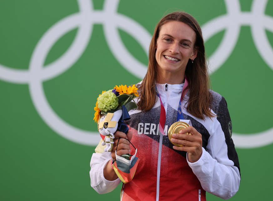 epa09369580 Gold medalist Ricarda Funk of Germany celebrates on the podium during the victory ceremony of the Canoe Slalom Final of the Canoeing Slalom events of the Tokyo 2020 Olympic Games at the Ka ...