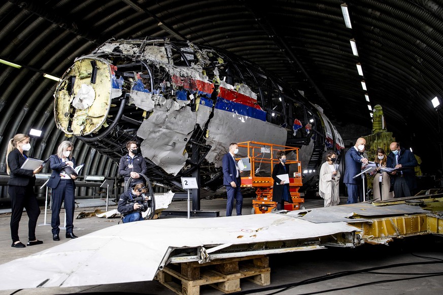 epa09228713 Members of the court view the reconstruction of the MH17 aircraft shot down in 2014 in Ukraine, at Gilze-Rijen air base, The Netherlands, 26 May 2021. The inspection is part of the MH17 cr ...