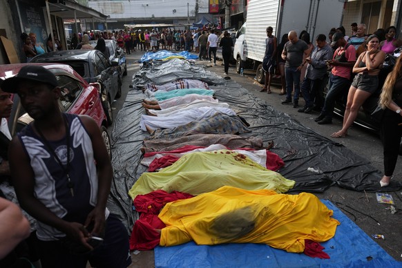 Resident look at the bodies people killed the day before during a police raid targeting the Comando Vermelho gang at the Complexo da Penha favela in Rio de Janeiro, Brazil, Wednesday, Oct. 29, 2025..( ...