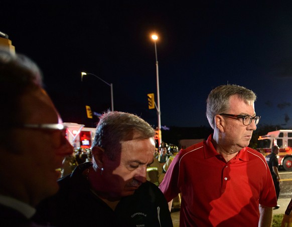 Ottawa Mayor Jim Watson, center, takes part in a briefing as paramedic gives an update following a tornado in Dunrobin, Ontario west of Ottawa on Friday, Sept. 21, 2018. A tornado damaged cars in Gati ...
