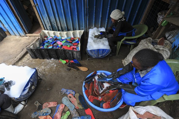 epa10228964 Kenyan workers from the social enterprise &#039;Ocean sole&#039; cleans old flip-flops as preparation for their further processing at their workshop in Nairobi, Kenya, 06 October 2022 (iss ...