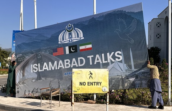epa12884435 Laborers remove billboards after the peace talks between US and Iran ends in Islamabad, Pakistan, 12 April 2026. The United States and Iran did not reach a deal after long talks in Islamab ...