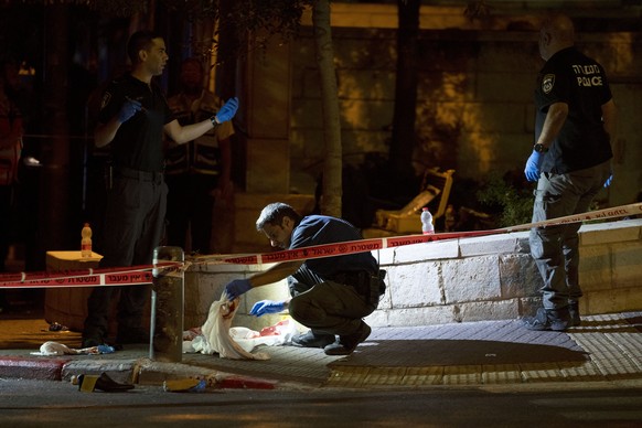 Israeli police crime scene investigators work at the scene of a shooting attack that wounded several Israelis near the Old City of Jerusalem, early Sunday, Aug. 14, 2022. Israeli police and medics say ...