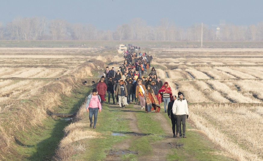 epa08263903 Refugees walk back after a failed attempt to pass the Greek border near the Meric (Evros) River, as they try to find a way to reach Greek territory at the Turkish-Greek border in the Ipsal ...